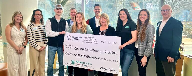 Eastwood team members holding charity check for Levine Children's Hospital