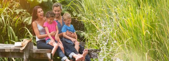 Family sitting by water